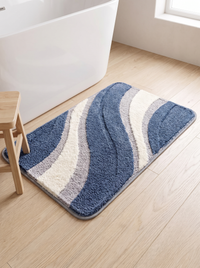 Scale reference showing the Nima bath mat on the floor alongside a freestanding bath and a small timber bathroom stool for size comparison