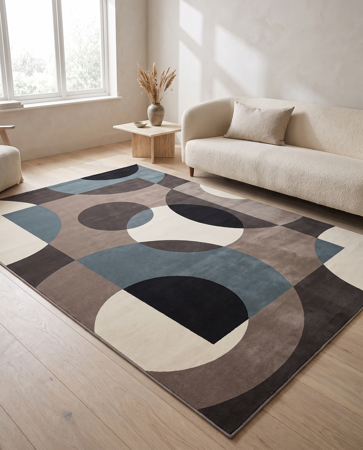 Lindo petrol geometric rug anchoring a warm-neutral living room with a cream boucle sofa and oak coffee table