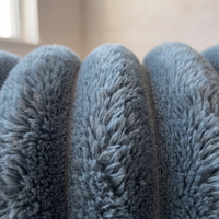 Close-up of the Nordo throw blanket's coral fleece pile, showing the depth of the fibres and the fine stitched seam between each raised rib