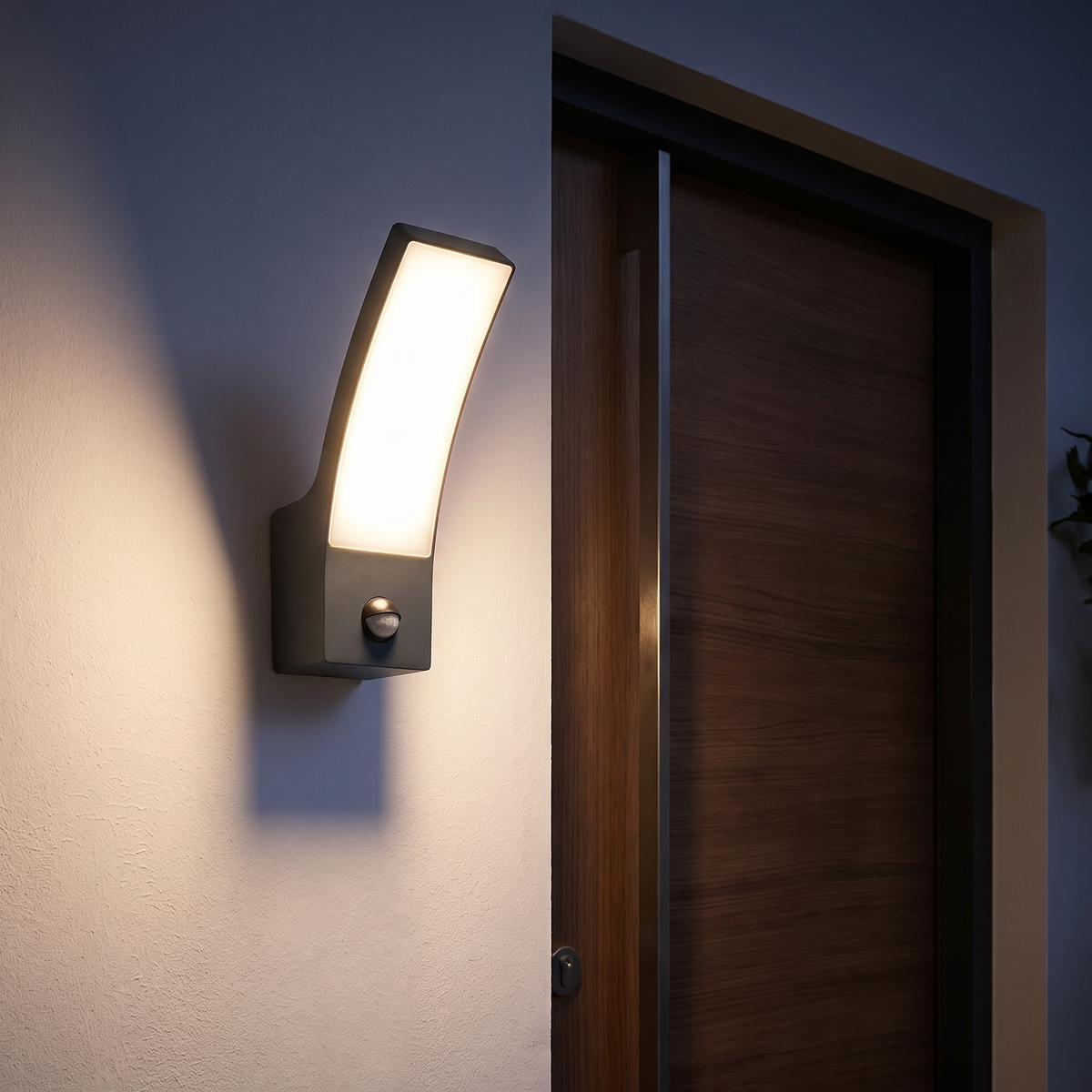 Ilvo sensor wall light beside a modern timber front door at night casting a wide warm glow