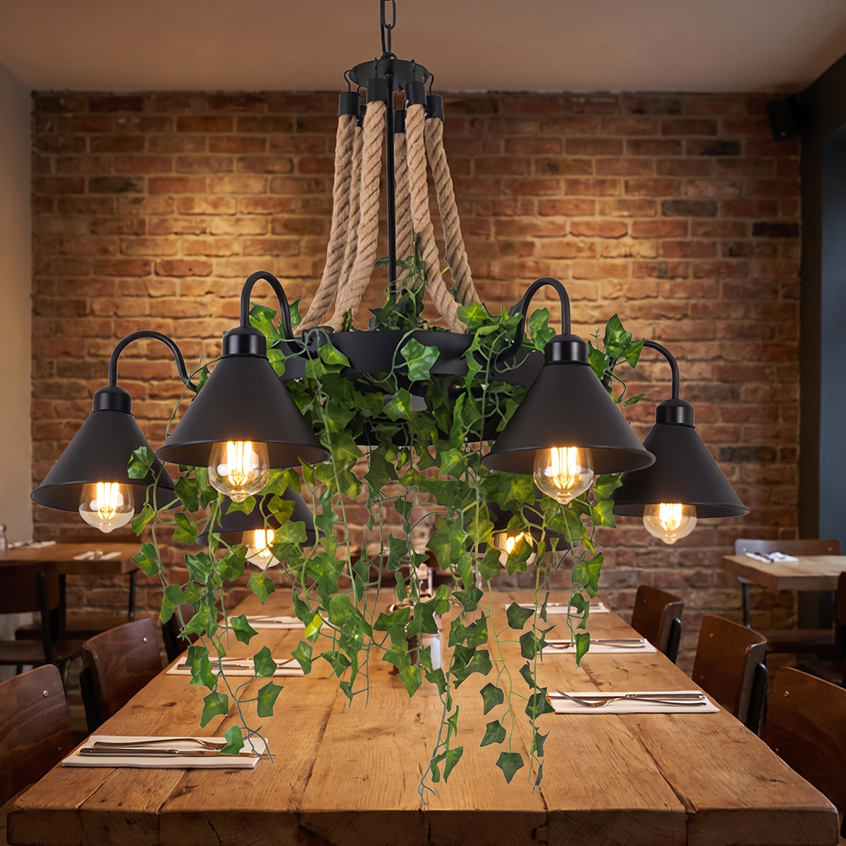 Corven six-arm ceiling light lit above a long reclaimed oak dining table against an exposed brick wall