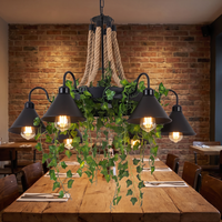 Corven six-arm ceiling light lit above a long reclaimed oak dining table against an exposed brick wall