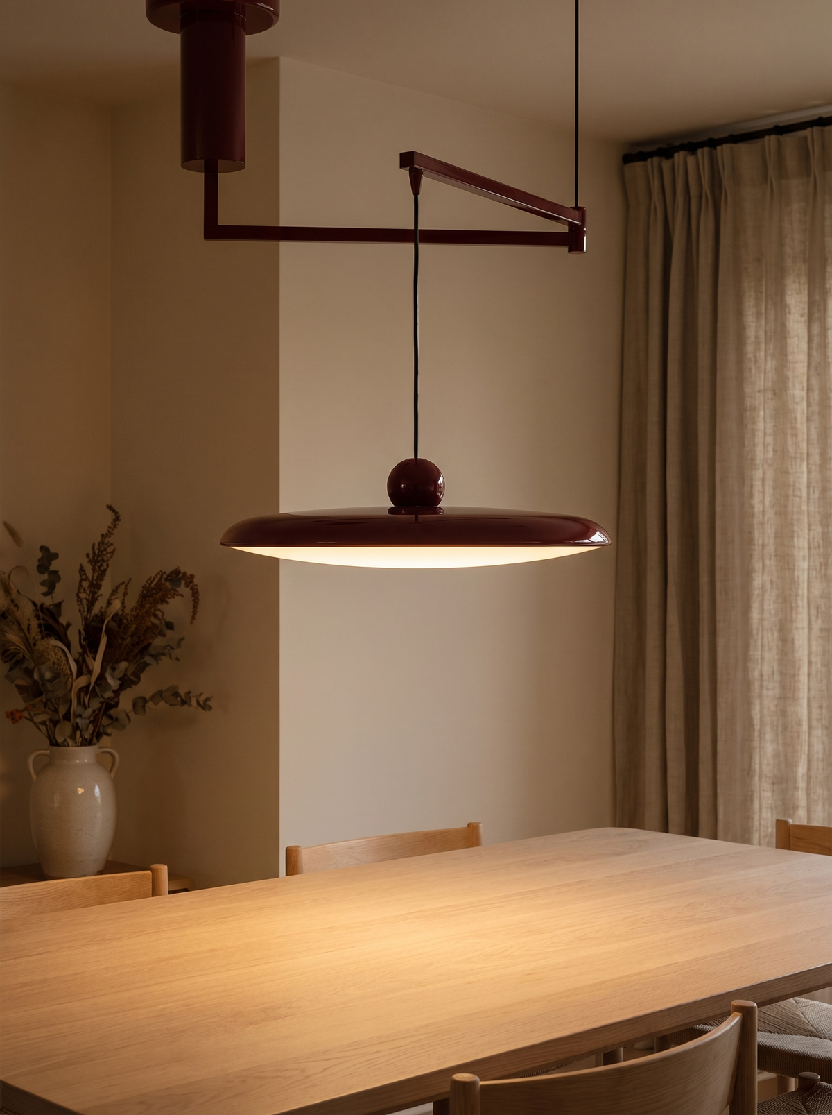 Fluxa Morandi Arm Pendant Light - red swing-arm pendant lit warm above oak dining table in UK interior