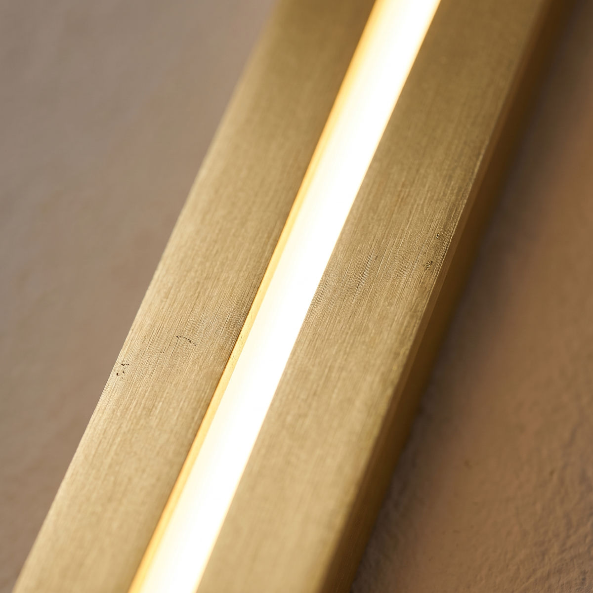 Azino Slim LED Wall Light - macro close-up of brushed gold finish and glowing LED diffuser slot