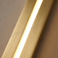 Azino Slim LED Wall Light - macro close-up of brushed gold finish and glowing LED diffuser slot