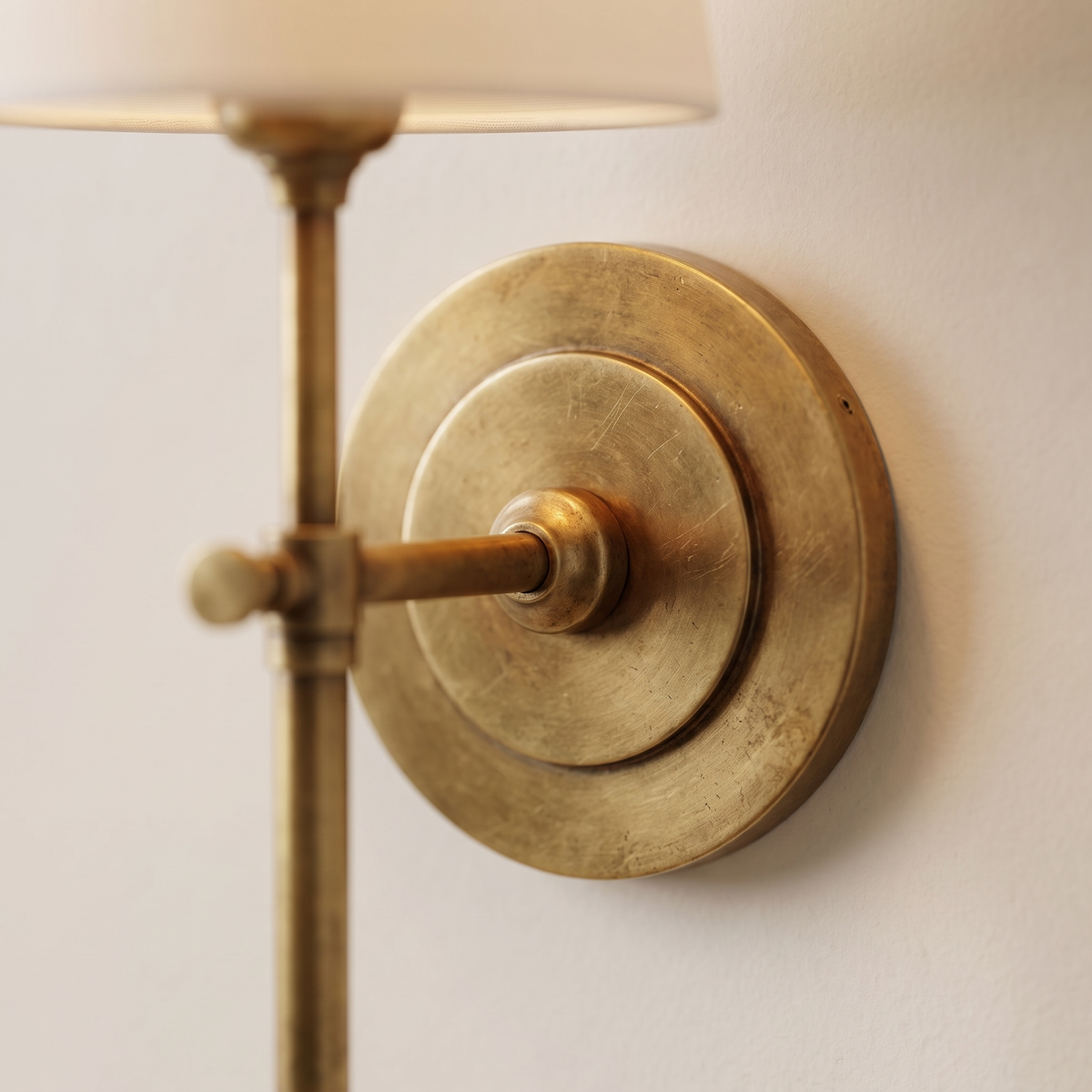 Thedo Brass Fabric Wall Light - macro close-up of antique brass backplate and stem collar detail