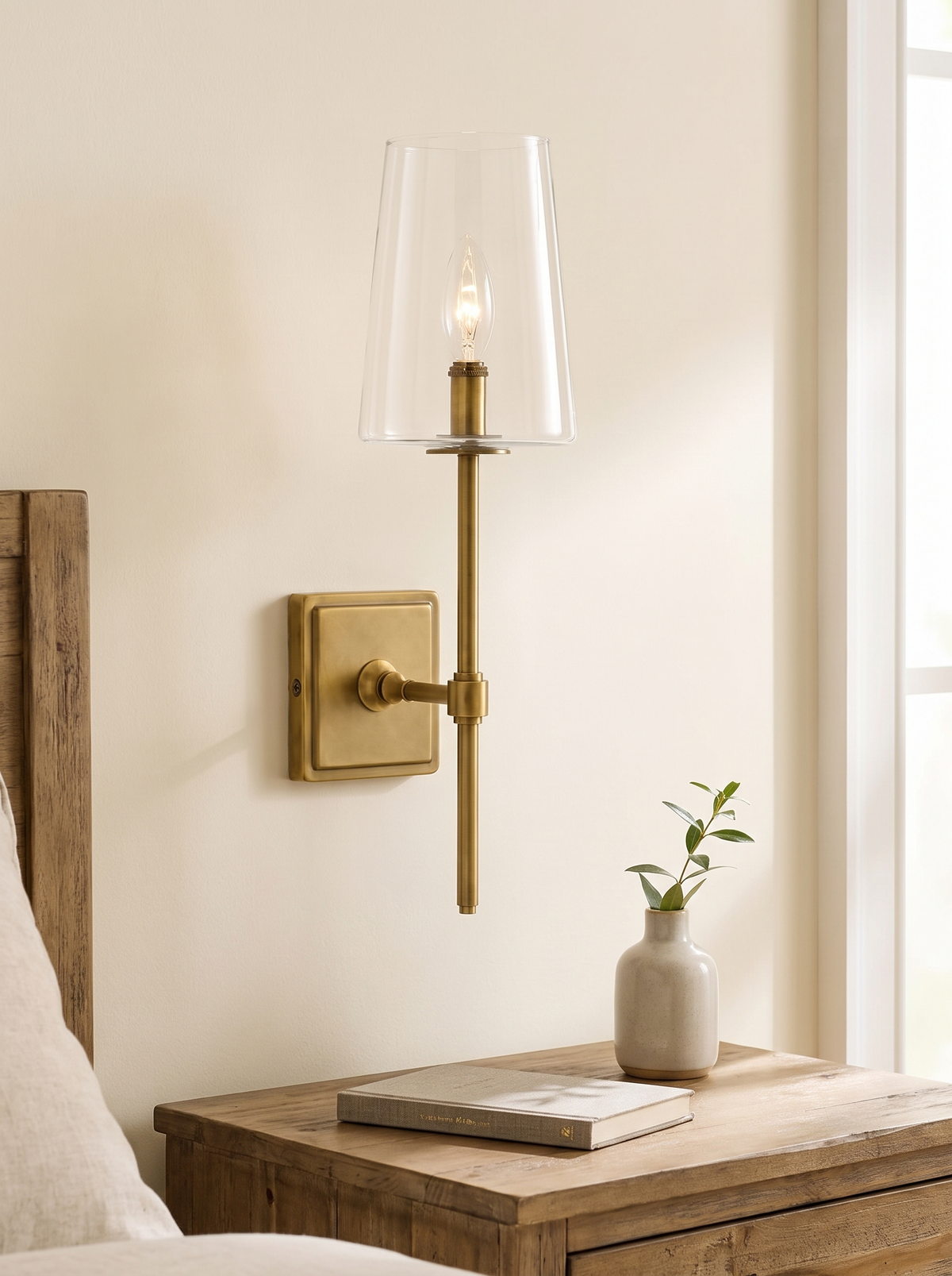 Torin Clear Glass Wall Sconce - scale lifestyle shot above timber bedside table with book and bud vase
