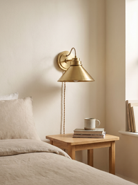 Arvo Bronze Cone Wall Light - scale shot above oak bedside table beside linen bed