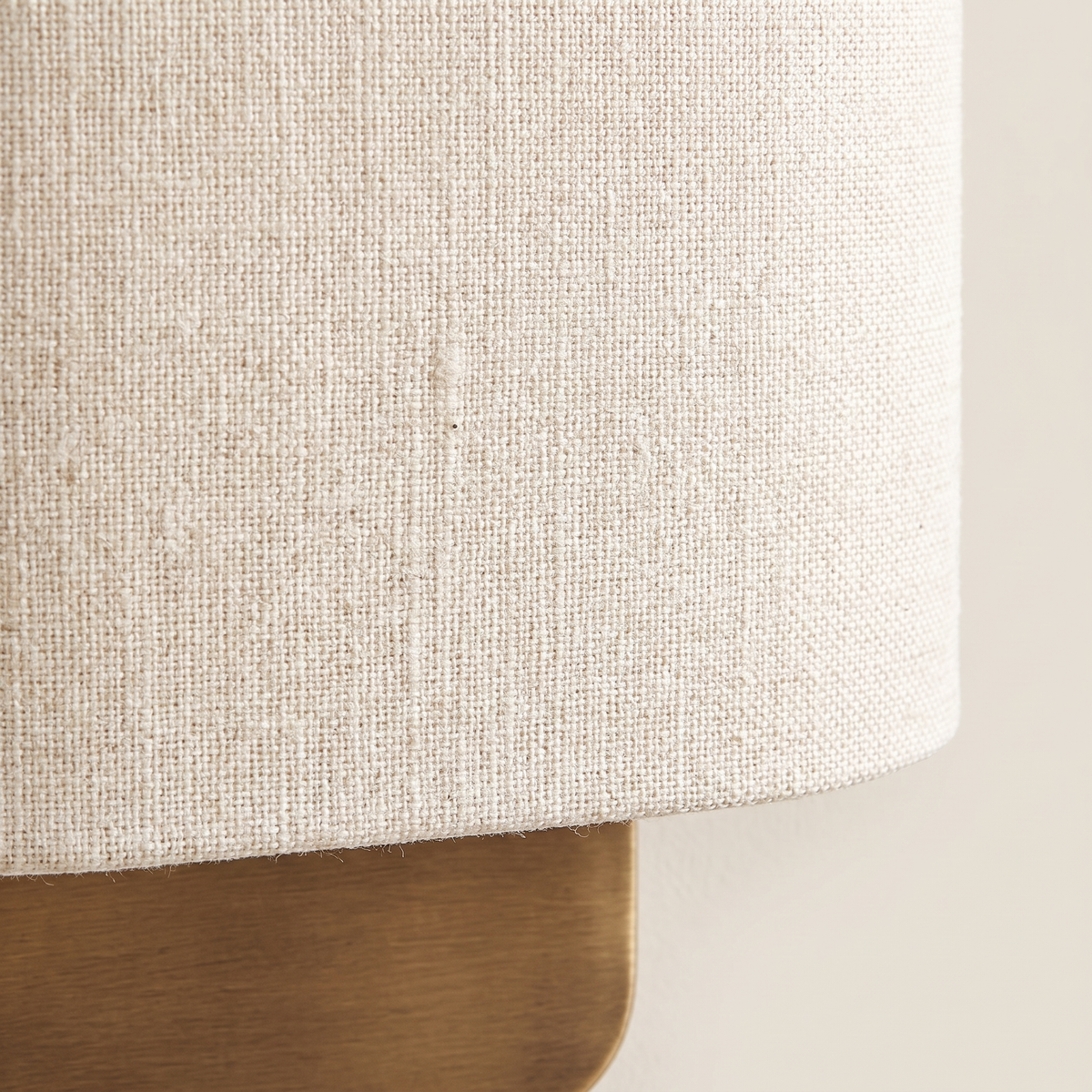 Lino Curved Linen Wall Light - macro close-up of natural linen weave and brushed brass backplate