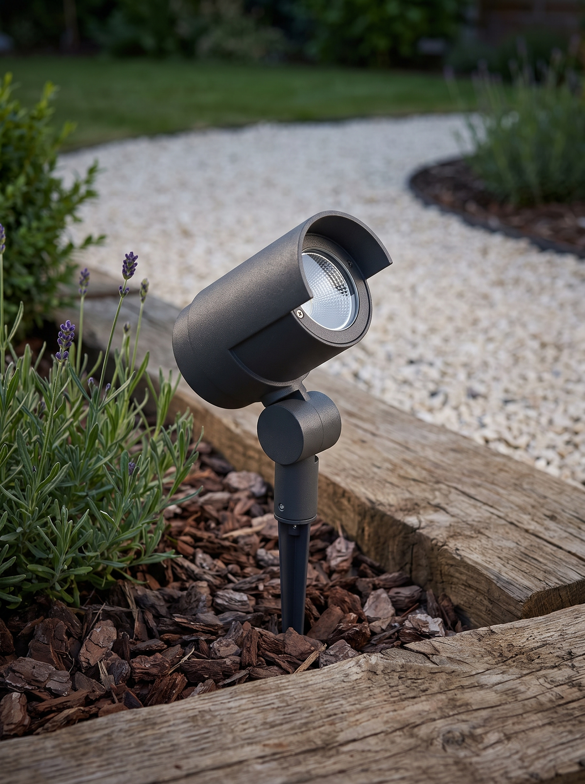 Batra Garden Spike Light - scale shot staked in mulched border beside timber sleepers and lavender