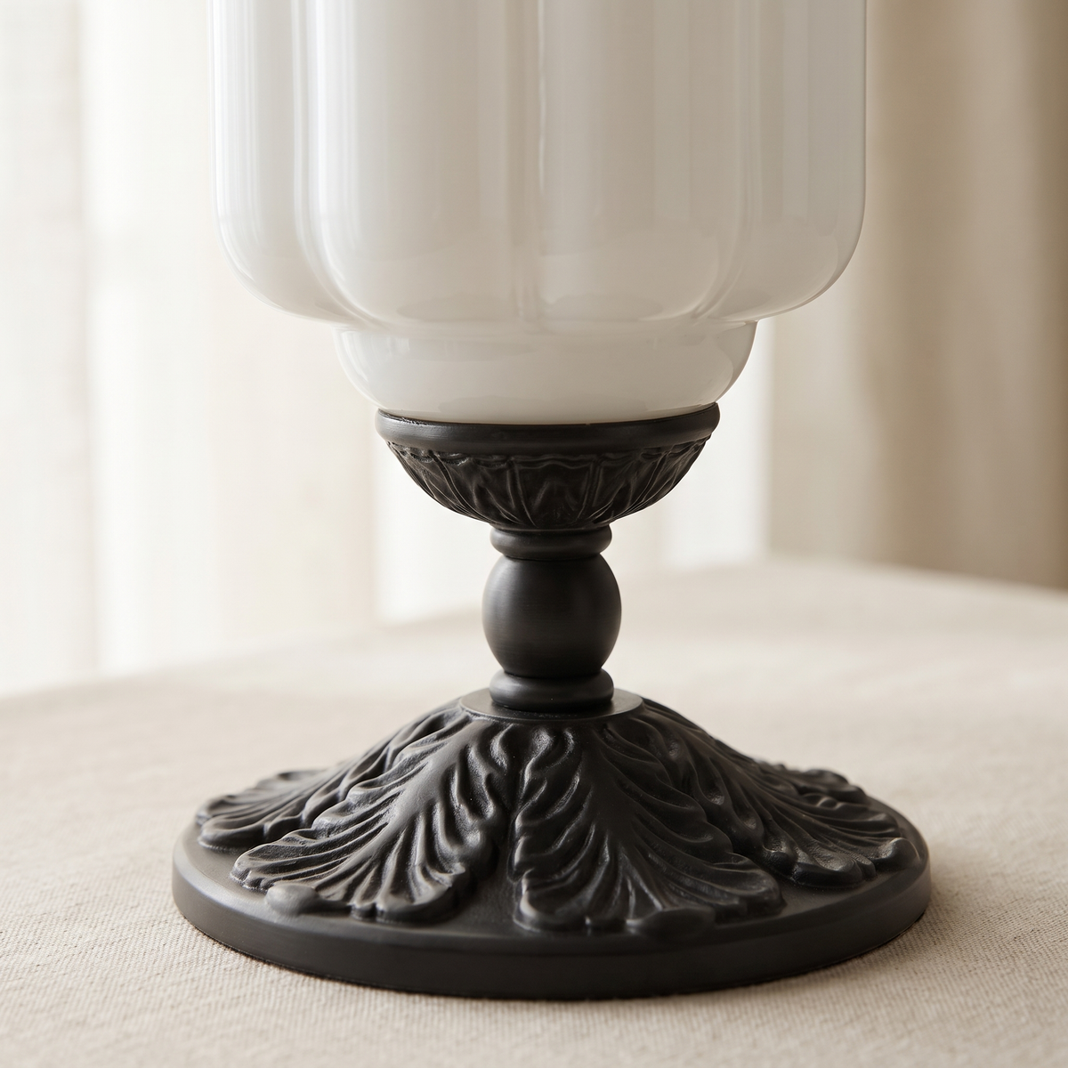Elva Glass Table Lamp - macro close-up of fluted opal glass body and ornate black cast metal acanthus leaf base