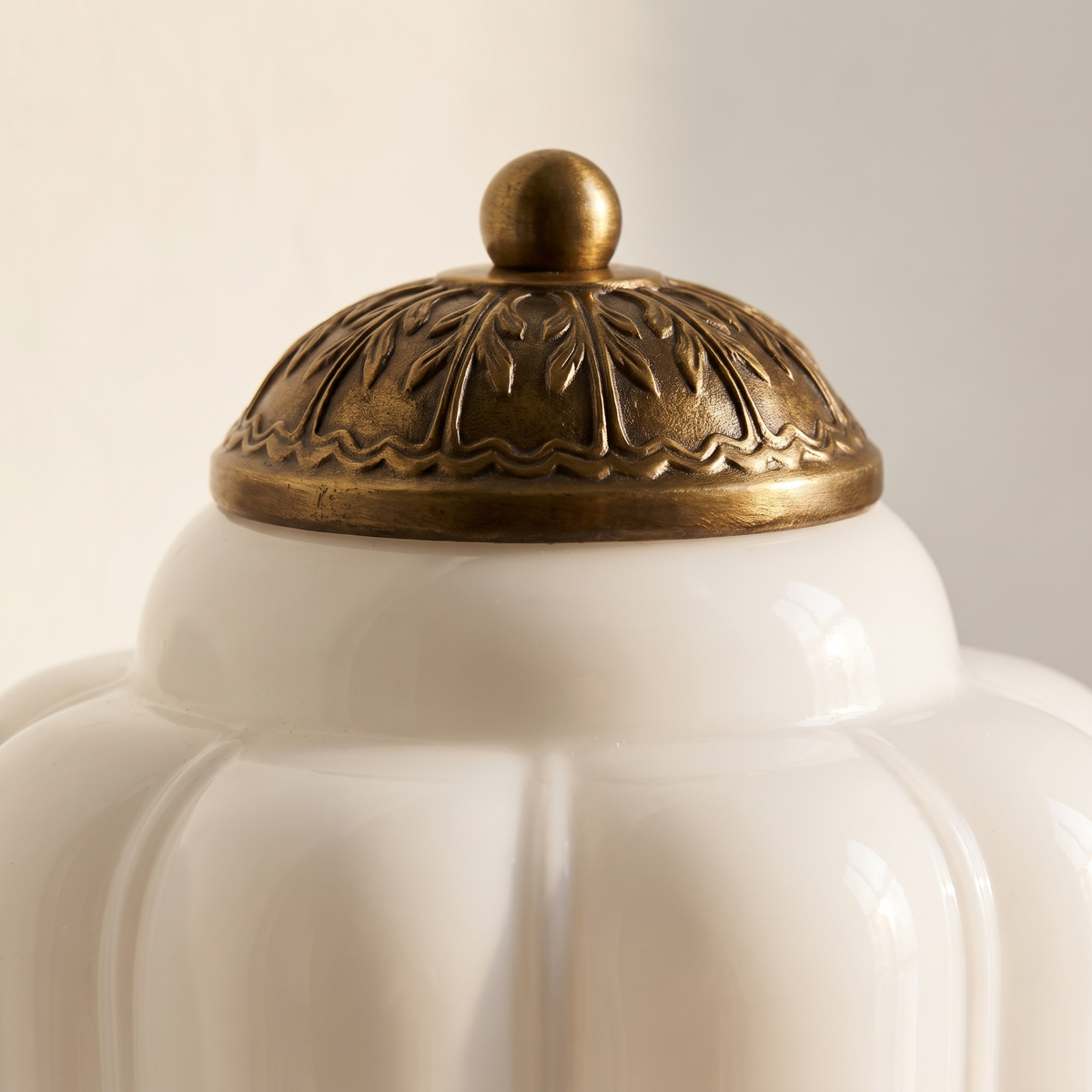 Faro Flush Milk Glass Wall Light - macro close-up of antique brass embossed cap and ribbed milk glass shade detail