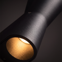 Kestro Torch Outdoor Wall Light - macro close-up of matte black powder-coat texture and warm LED glow from curved angled opening