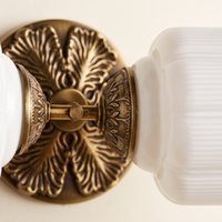 Lanto Horizontal Milk Glass Wall Light - macro close-up of ornate antique brass rosette and ribbed milk glass shade