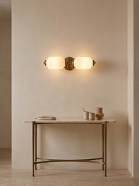 Lanto Horizontal Milk Glass Wall Light - warm glowing lifestyle above marble console in cream plaster interior