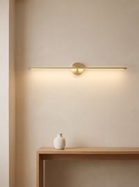 Rodo Double-End Linear Wall Light - lifestyle above oak console table with white ceramic vase, warm 2700K glow on cream wall