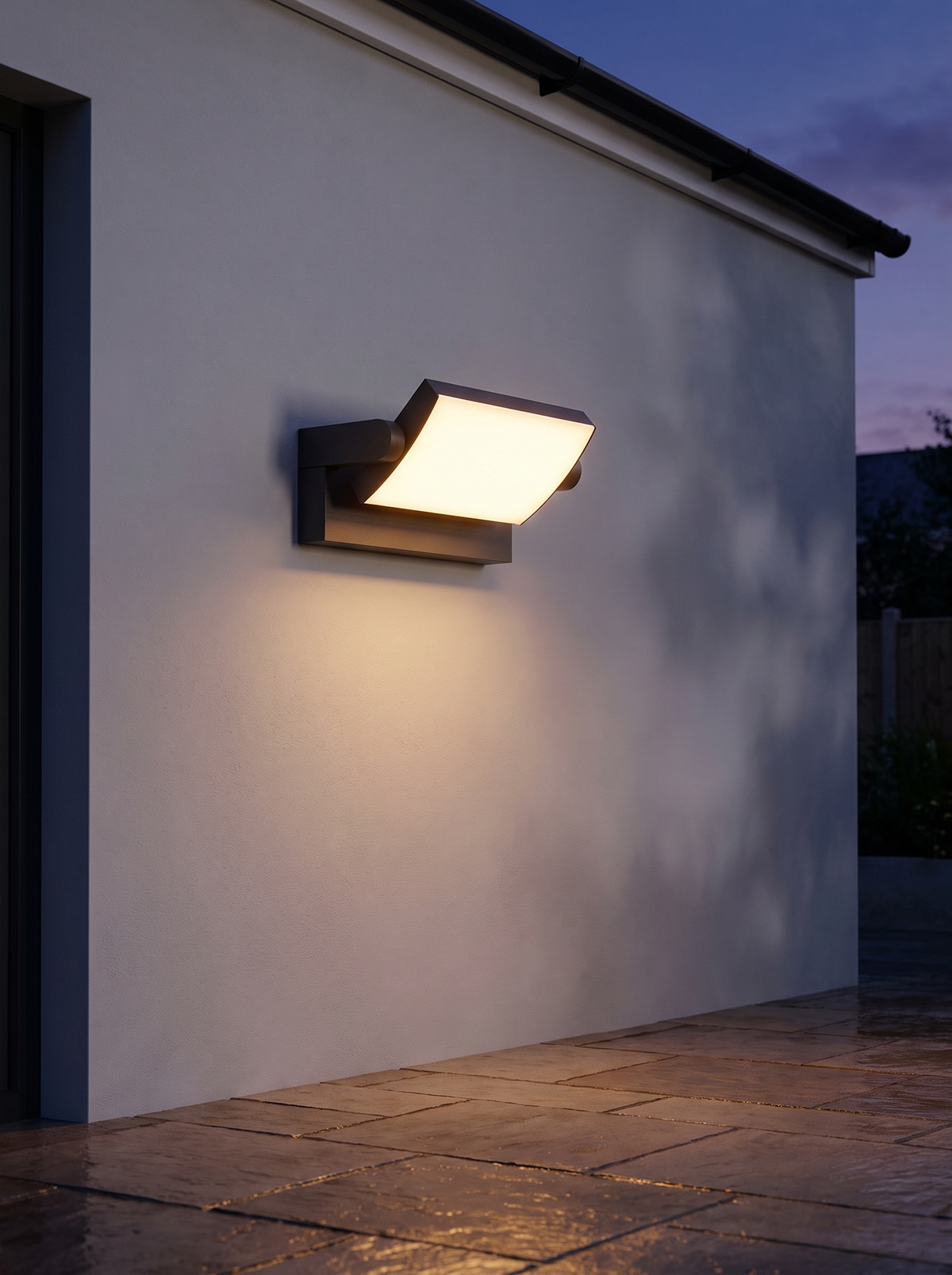 Shiro Swivel Outdoor Wall Light - lifestyle on rendered exterior wall at dusk glowing warm amber 2700K