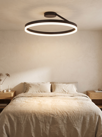 Soleno Circle Ceiling Light - lifestyle scale shot above a double bed with oat linen bedding and oak side tables in a neutral bedroom