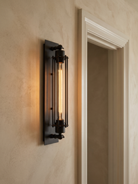 Trono Cylinder Wall Light - mounted on warm limewash plaster wall beside white door frame, warm amber glow, scale context