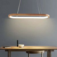 Veona oval wood pendant light casting a warm pool of light over a wooden dining table