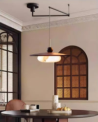 Turlo pendant light hanging over a round dining table in a period room with arched windows