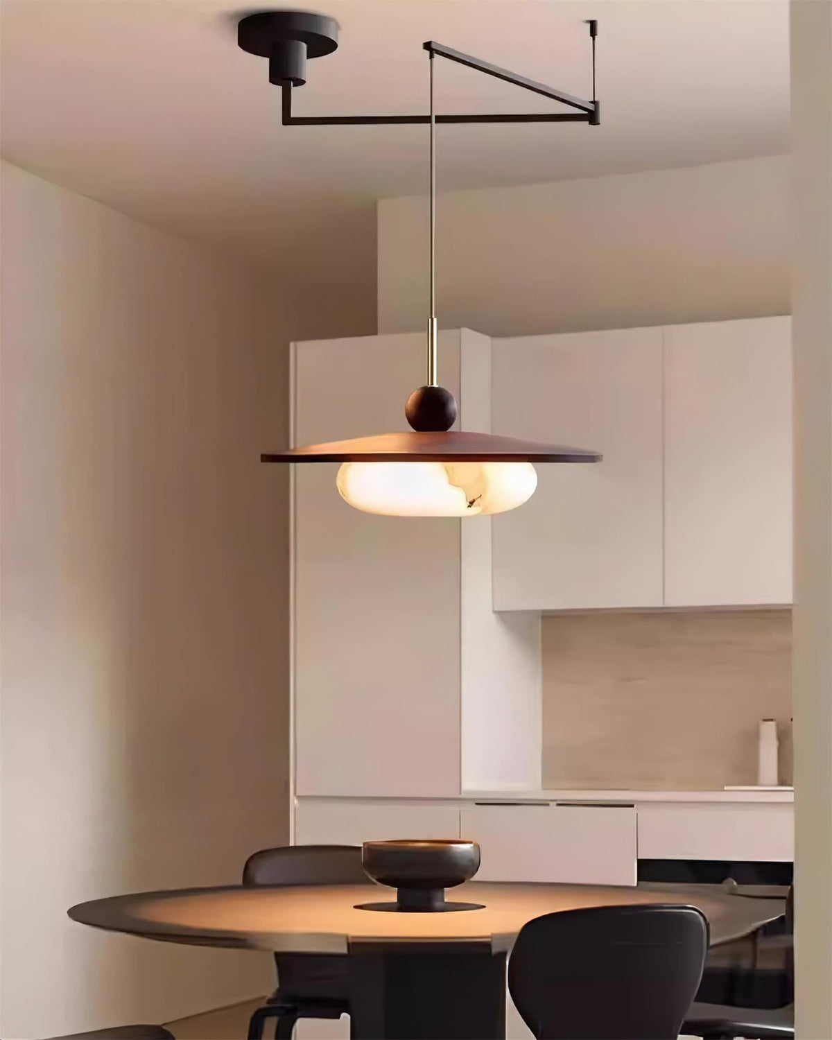 Turlo pendant light suspended above a dining table in a pale modern kitchen
