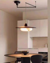 Turlo pendant light suspended above a dining table in a pale modern kitchen