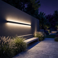 Sela linear wall light washing light on a garden wall at night