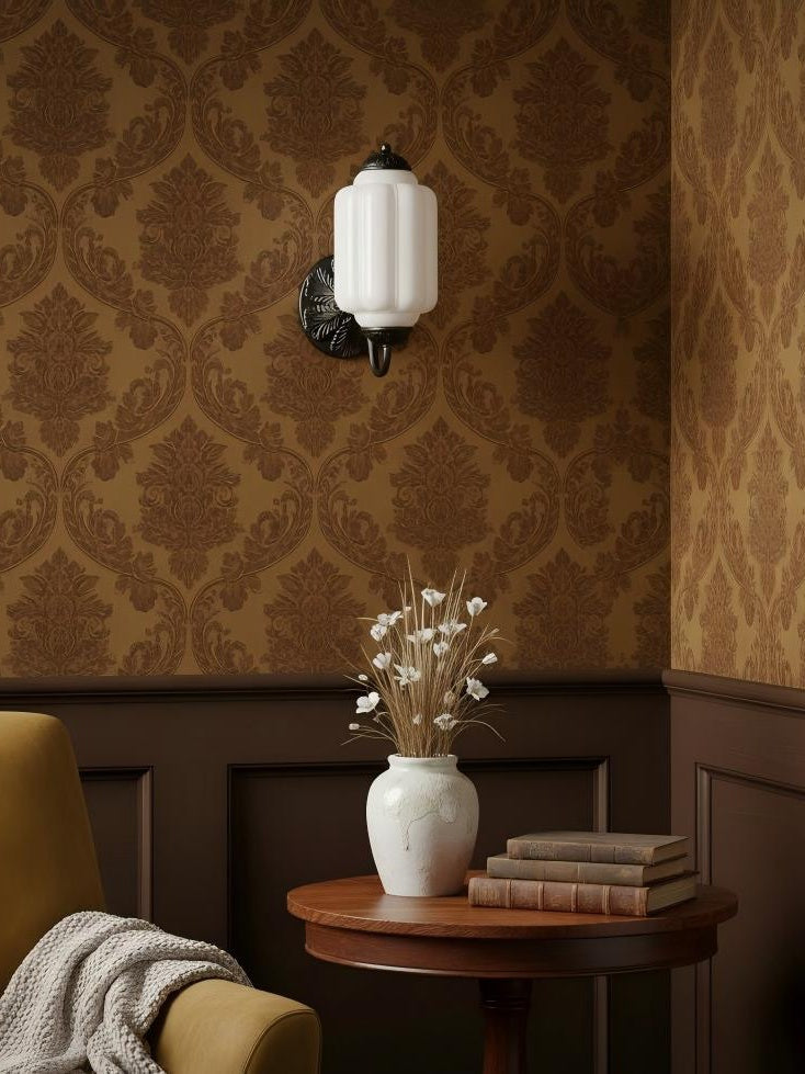 Elva milk glass wall sconce lighting a reading corner with a side table