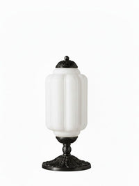 Elva glass table lamp with white opal glass body and black cast metal base on a plain background